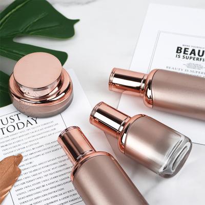 China Silk Screen Printing Or Other Gold Frosted Silver Glass Cosmetic Bottle 40ml 30ml Lotion Bottle With Pump for sale