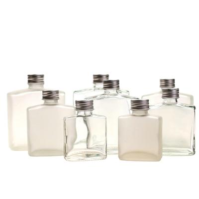 China Liquid Packing Bottle 100ml Flask Clear Glass Bottles Cold Flat Square Coffee Vodka Bottle With Screw Metal Cap for sale