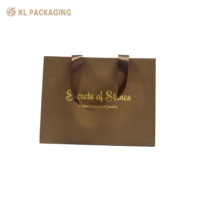 China Bolsas de embalaje de papel hechas a mano Bolsas de compras cosméticas biodegradables con mango en venta