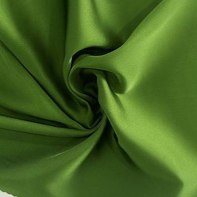 China Tejido de poliéster elástico de satén 50D*50D+20D 92GSM para vestidos y vestidos en venta