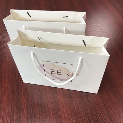 China Custom Printing Recyclable Stylish New Design Shopping Bag White Paper Packaging Bags With Silver Foil Gold Logo for sale