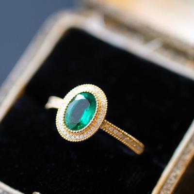 China Emerald Engagement Ring Green Gemstone Oval TRENDY Ring With Diamonds in 14K Yellow Gold Milgrain Design for sale