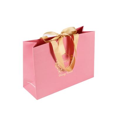 China Recyclable Custom Design Paper Bag Art Paper Gold Logo Foil Pink Gift Package Stamping Shopping Paper Bag for sale