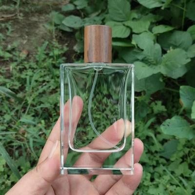 China Wholesale Luxury Cosmetic 30ml 50ml 100ml Polished Clear Glass Perfume Spray Bottles For Men And Women With Wooden Cap for sale