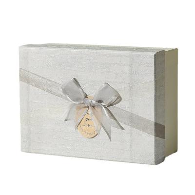 China Recyclable Custom luxury white magnet flap clothing paper box foldable magnetic closure gift boxes with colorful ribbon for sale