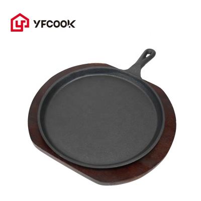 China Sustainable Round Sizzling Dish Cast Iron Fajita Skillet With Wooden Base for sale