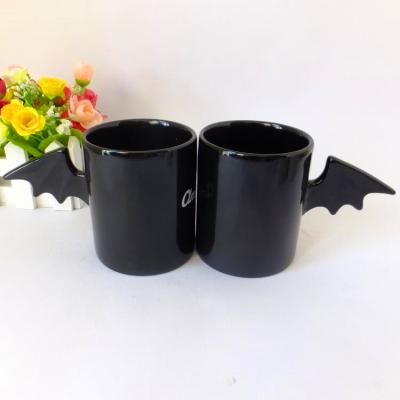 China Viable creative special 2021custom wing handle matte black color magic ceramic coffee mugs for sale