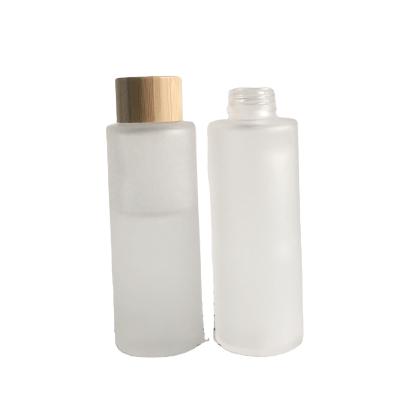 China Cosmetic Packaging Whole Clear Frosted Glass Bottle 100ml With Bamboo Screw Lid For Cosmetic Toner Packaging for sale