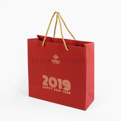 China Custom Recycled Materials 2022 New Year Biodegradable Fancy Paper Christmas Red Printed Shopping Gift Bags With Gold Twine Handles for sale