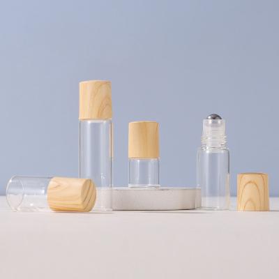 China 1ml2ml3ml5ml personal care bottle suitable for essential oils natural clear glass roller bottles wooden caps, thick glass bottle for sale