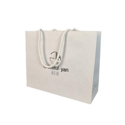 China Recyclable Lychee Pattern Gift Bag Handheld Gift High Grade Embossed Paper Bag For Clothing for sale