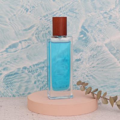 China Cosmetic Flat Shoulder 50ml Empty Glass Spray Perfume Bottle With Wooden Lid for sale