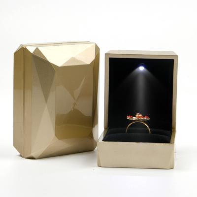 China Caja de embalaje de joyería de plástico de oro de PU con LED Light en venta