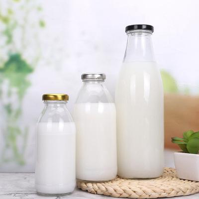 China Sustainable/Eco-Friendly/Stored Wholesale Food Grade 250ml- 1L Empty Round Clear Glass Storage Bottle Cool Milk Tea Drink Bottle With Tinplate Lid for sale