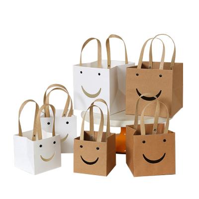 China Biodegradable Wholesale Custom Smile Paper Gift Shopping Bottom White Brown Lipack Face Square Kraft Paper Packaging Bags With Flat Handle for sale