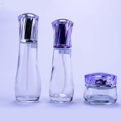 China OEM Style Skincare Glass Custom Bottle Set Empty Lotion Pump Bottles Packaging With Purple Acrylic Cap for sale