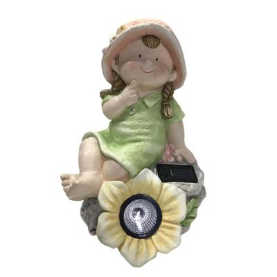 China Handmade Outdoor Boy And Grill Sitting On Sunflower Garden Solar Light Statues Molds Decoration for sale