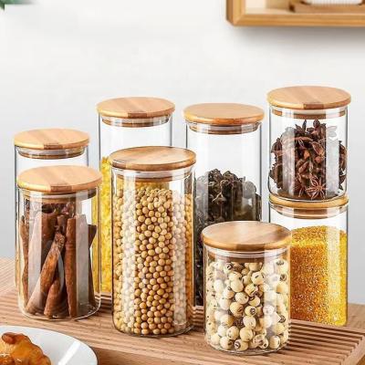 China Factory direct sales 1000ml 1500ml kitchen food glass storage tank heatable transparent circular sealed tank with bamboo and wooden cover for sale