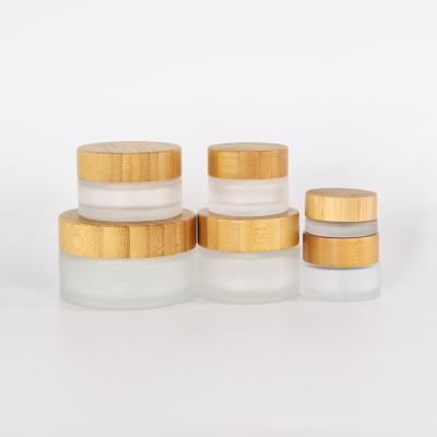 China Personal care 5g 15g 30g 50g 100g light green amber cosmetic frosted bamboo glass jars packaging with bamboo lid, cosmetic glass jar for sale