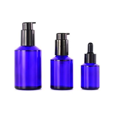 China Recyclable Empty Glass Cosmetic Cobalt Blue Lotion Pump Bottles for sale