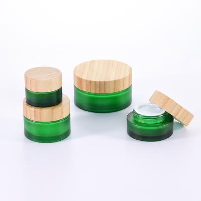 China Hot Sale Personal Care Face Cream Container 20ml 30ml 50ml 100ml Cosmetic Green Frosted Glass Jar With Bamboo Lid for sale