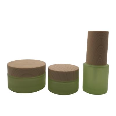 China 4oz cosmetic frosted green glass jar with bamboo lids for sale