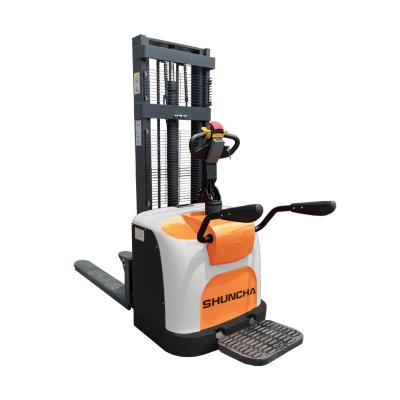 China Hotels SHUNCHA 1.6ton/2ton Stand On Type Electric Pallet Stacker Battery Operated Forklift With Protection Arm for sale