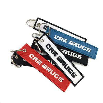 China Durable Customized Double Sided Embroidered Car Logo Fabric Kiss Before Flight Embroidered Key Chain for sale