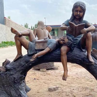 China Wholesale Metal Crafts Europe Factory Garden Children Statue Children Bronze Reading Book On Tree Log Sculpture for sale