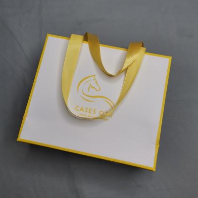 China Recyclable custom printed luxury logo white paper shopping carry on gift packaging bag with ribbon handles for store for sale