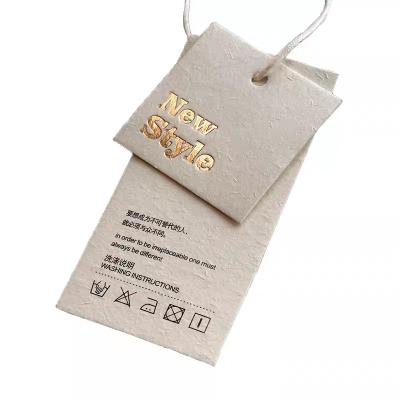 China Sustainable Specialty Paper Material Paper Hang Tag For Clothing Gold Vanilla Foil Logo Customized Printing Garment Paper Tags Swing Tags for sale