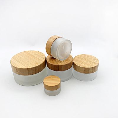 China Personal Care Skin Care Packaging 50ml Frosted White Cosmetic Glass Jar With Bamboo Lid Cream Container for sale