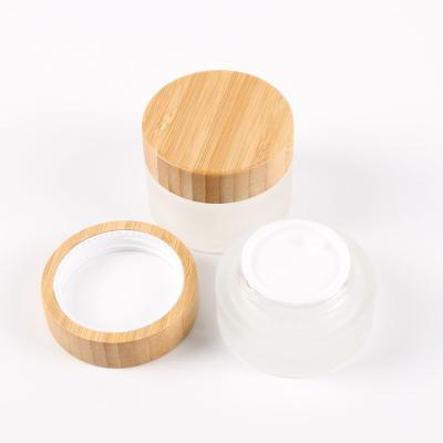 China Personal care factory price 5g 10g 15g 30g 50g 100g or custom frosted cream glass jar with wooden cap for sale