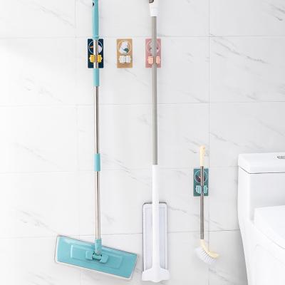 China Self Adhesive Toilet Broom Holder Storage Wall Mounted Broom Brush Clip Hanger Corrosion And Rust Prevention Cartoon Bathroom for sale