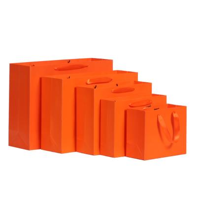 China Recyclable Custom Plain Luxury Orange Gift Paper Bag Clothing Packaging With Handle for sale