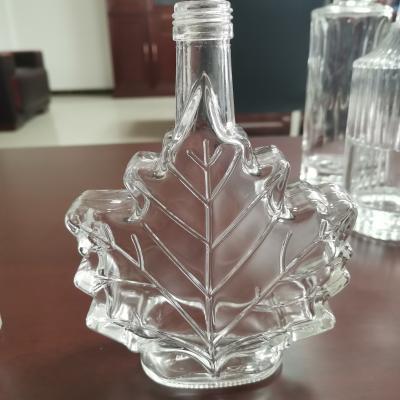 China Glass Collar 50ml Empty Maple Leaf Shaped Crew Top Glass Bottle 100ml Mini Glass Bottle for sale