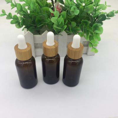 China 30ml round glass amber essential oil bottle with bamboo dropper for sale