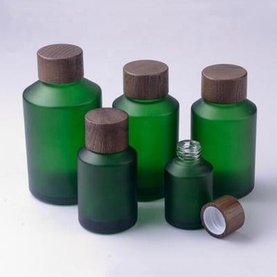 China 60ml green frosted glass bottle with wooden screw lid for sale