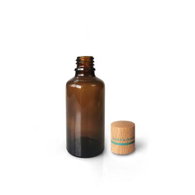 China 50ml Amber Glass Eco - Friendly Essential Oil Bottle With Bamboo Cap For Refillable Sustainable Cosmetic Packaging for sale