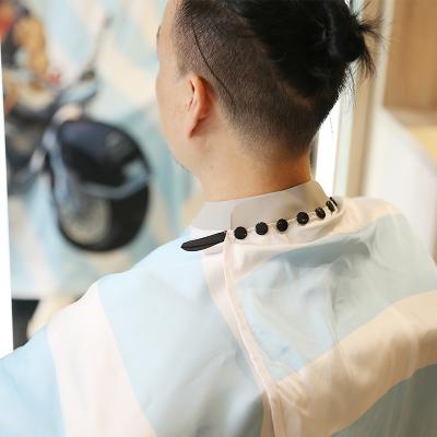 China Waterproof Blue Silicone Neck Nylon Barber Hairdresser Cape Fashion Barber Cape With Buttons for sale