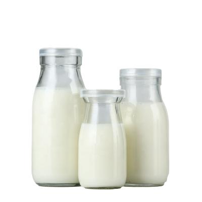 China Beverage Stain Goods Beverage Glass Bottles Empty Juice Milk Bottles With Plastic Transparent Cover for sale