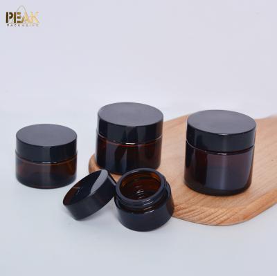 China 30ml 50ml 60ml 80ml 100mlamber cosmetic glass cream jar with black plastic lid for sale