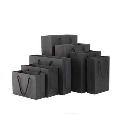 China Recyclable in stock luxurious thickening black paper kraft bag with handle for clothing for sale