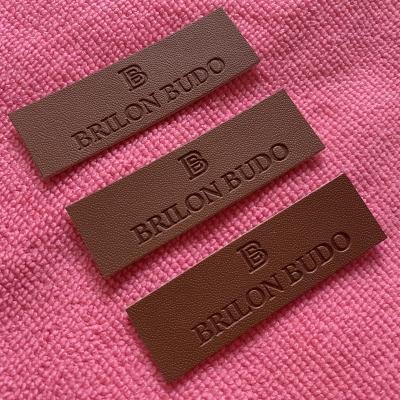 China Viable Cheap Price Heat Press Logo Artificial Leather Patch , Debossed Logo Brown Fake Leather Label For Coats for sale