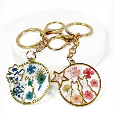 China Fashionable Wholesale Flower Key Chains Designer Metal Key Chains Gift Resin Dry Key Chains for sale