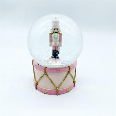 China Europe Factory Price 120MM Online Shopping Resin Walnut Soldiers Christmas Snow Glass Globes With Pink Base for sale