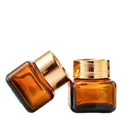 China Cosmetic Hot selling 20g square glass eye cream jar amber glass cosmetic jar with golden lid for sale