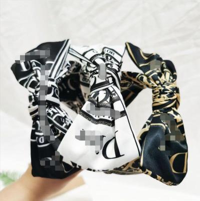 China Popular Designer Wide Side Bowknot Letter Print Wide Side Circle Bowknot Hair Band Bandana Women Cross Non-slip Luxury Hair Accessories for sale