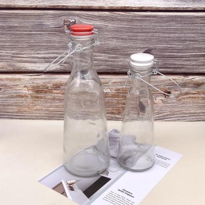 China Wholesale Customized Glass Beverage Label Bottle With Locked Lifting Lid 500ml 1000ml Milk Beverage Bottle for sale