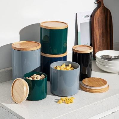 China Bright Colorful Glazed Stackable Steamable Kitchen Canisters Porcelain Storage Jar Containers With Airtight Seal Wooden Lid for sale